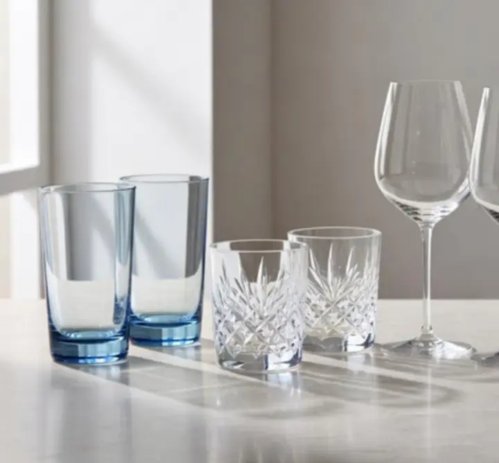 Różne kategorie szkła stołowego posegregowane na eleganckim stole.